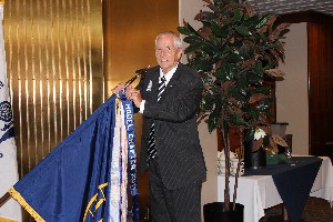 Terry Miller, chapter deputy for programs, displays the chapter's recently received Model Chapter Award banner for 2011.